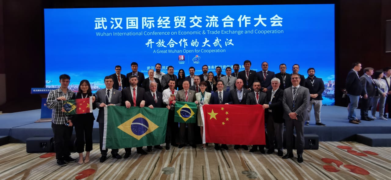 Na foto, grupo de pessoas em pé seguram bandeiras do Brasil e da China