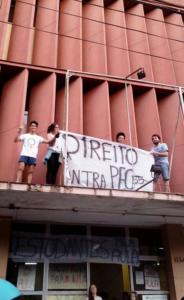 Foto colorida de quatro jovens segurando uma faixa escrito direito contra PEC 55