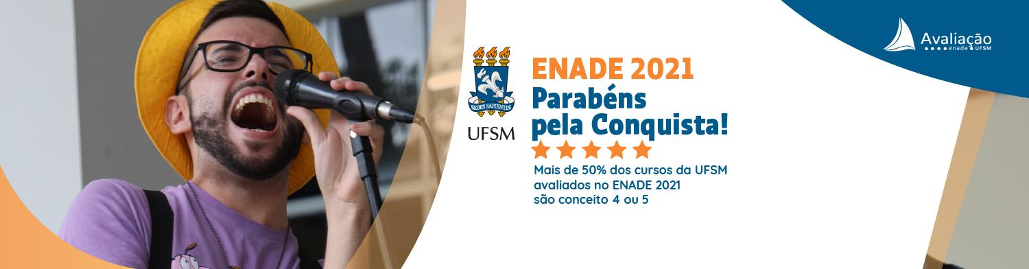 Banner branco com foto de estudante cantando e texto: Enade 2021 Parabéns pela conquista! Mais de 50% dos cursos da UFSM avaliados pelo Enade 2021 são conceitos 4 e 5