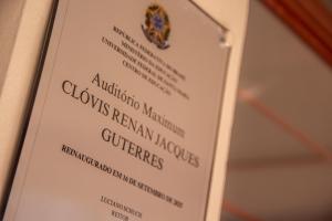 Foto horizontal que, em um plano levemente inclinado para a direita, mostra a placa de reinauguração do auditório.