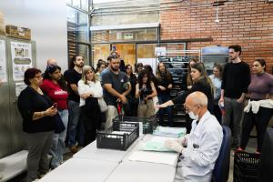 Foto horizontal e colorida de um grupo de pessoas observando uma das etapas de recuperação de arquivos.