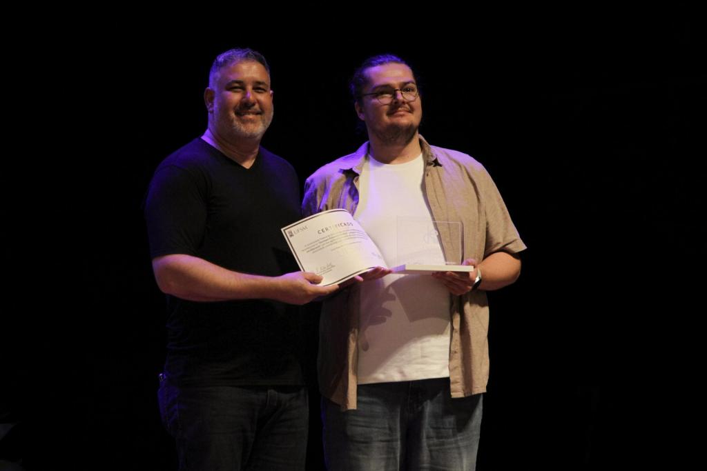 Foto colorida horizontal de Flávio Augusto Pretto recebendo prêmio