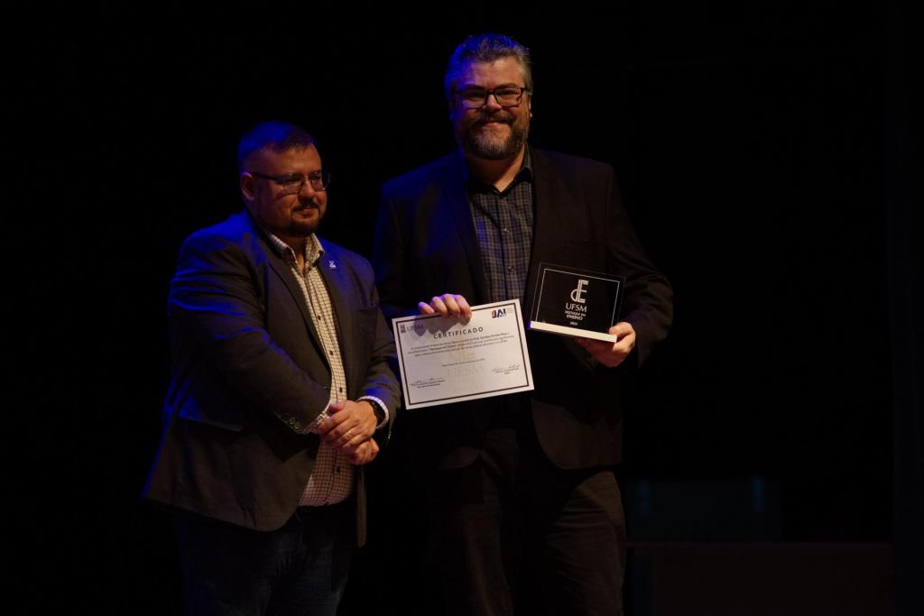 Foto colorida horizontal do professor Günther recebendo certificado do professor Jerônimo