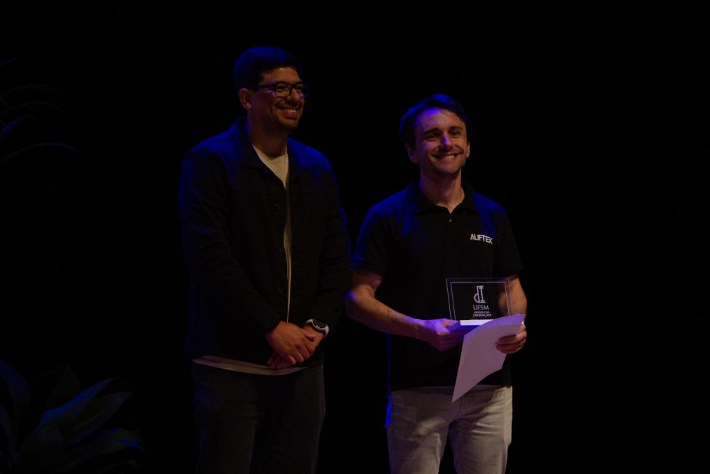 Foto colorida horizontal do Adriano Marques recebendo prêmio