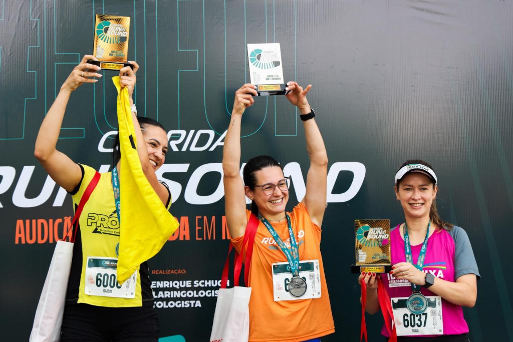 foto colorida horizontal de 3 mulheres em um pódio