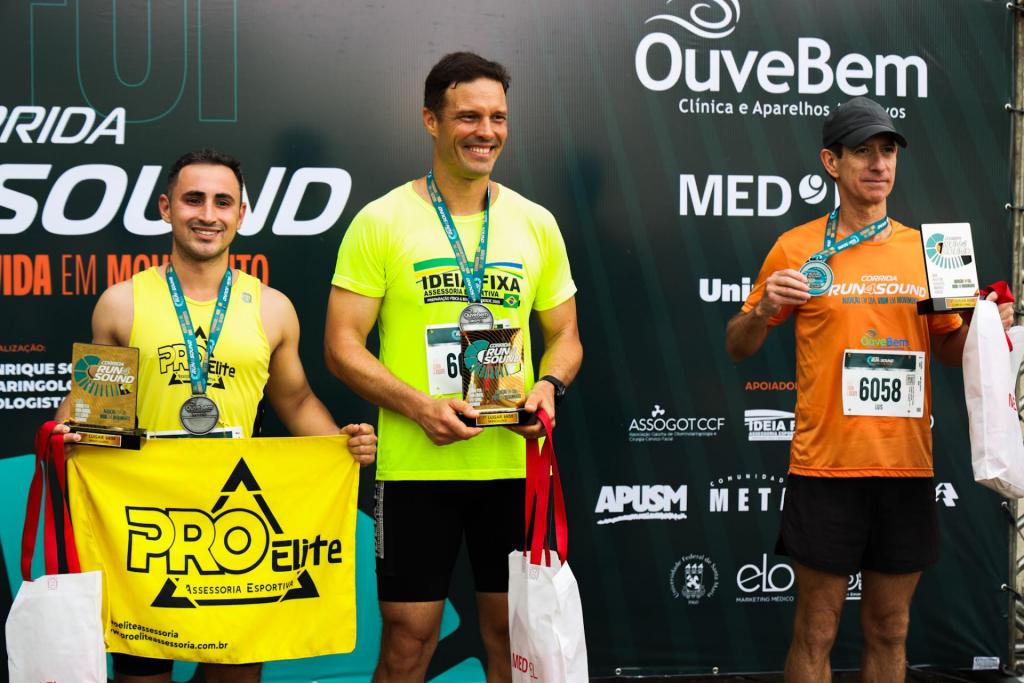 foto colorida horizontal de 3 homens num pódio