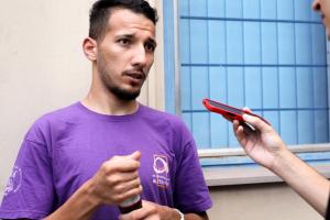 Foto horizontal e colorida de Leonardo Barcelos com a camiseta do Pré-Universitário Popular Alternativa (Pupa)