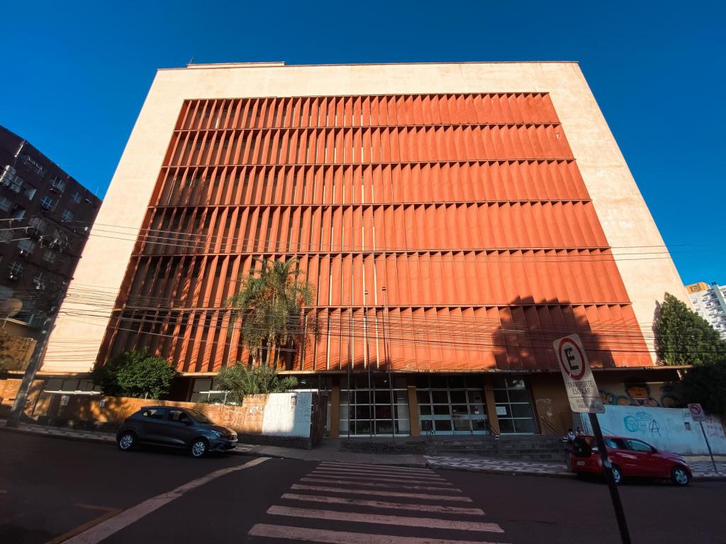 Foto colorida horizontal da fachada do prédio da Antiga Reitoria. A imagem mostra o prédio a partir de uma vista de baixo para cima. No momento da foto, a céu está firme e azulado.