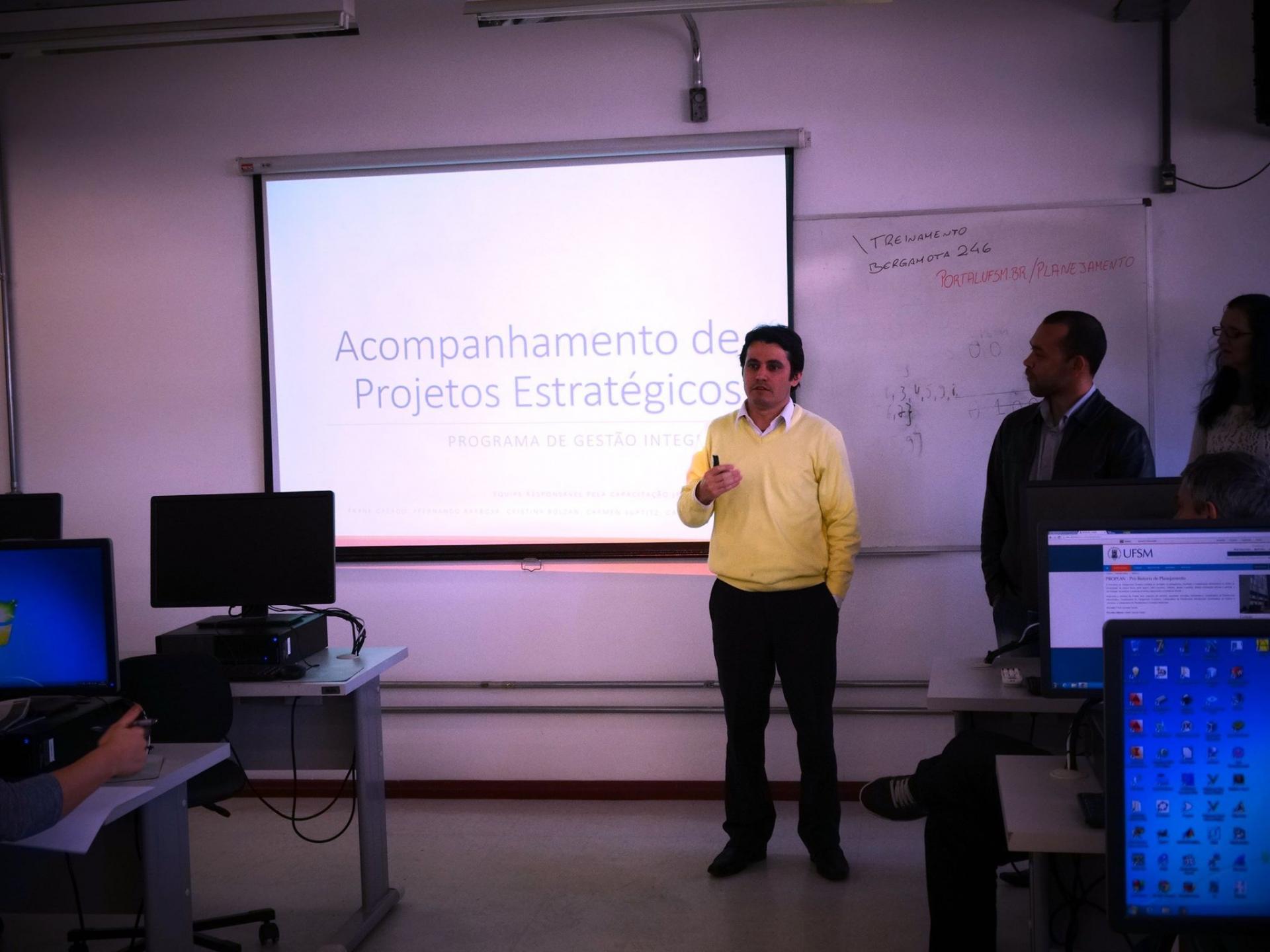 Homem apresenta slide.