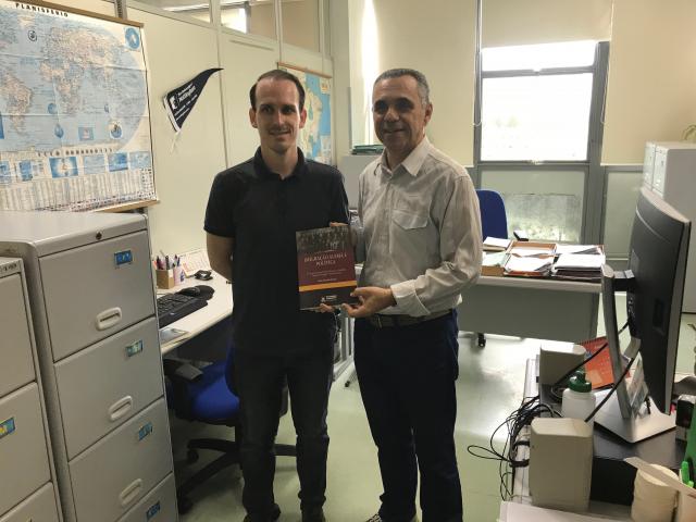 Dois homens brancos segurando um livro.