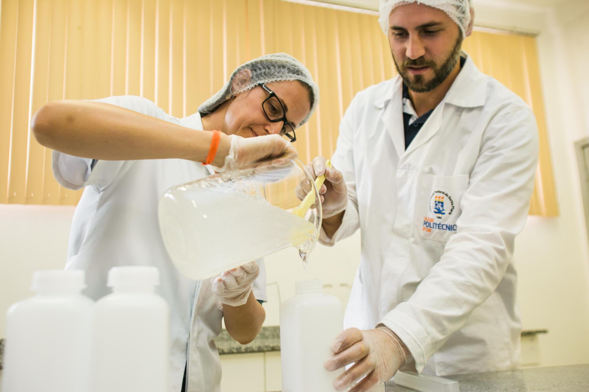 Duas pessoas produzindo álcool gel