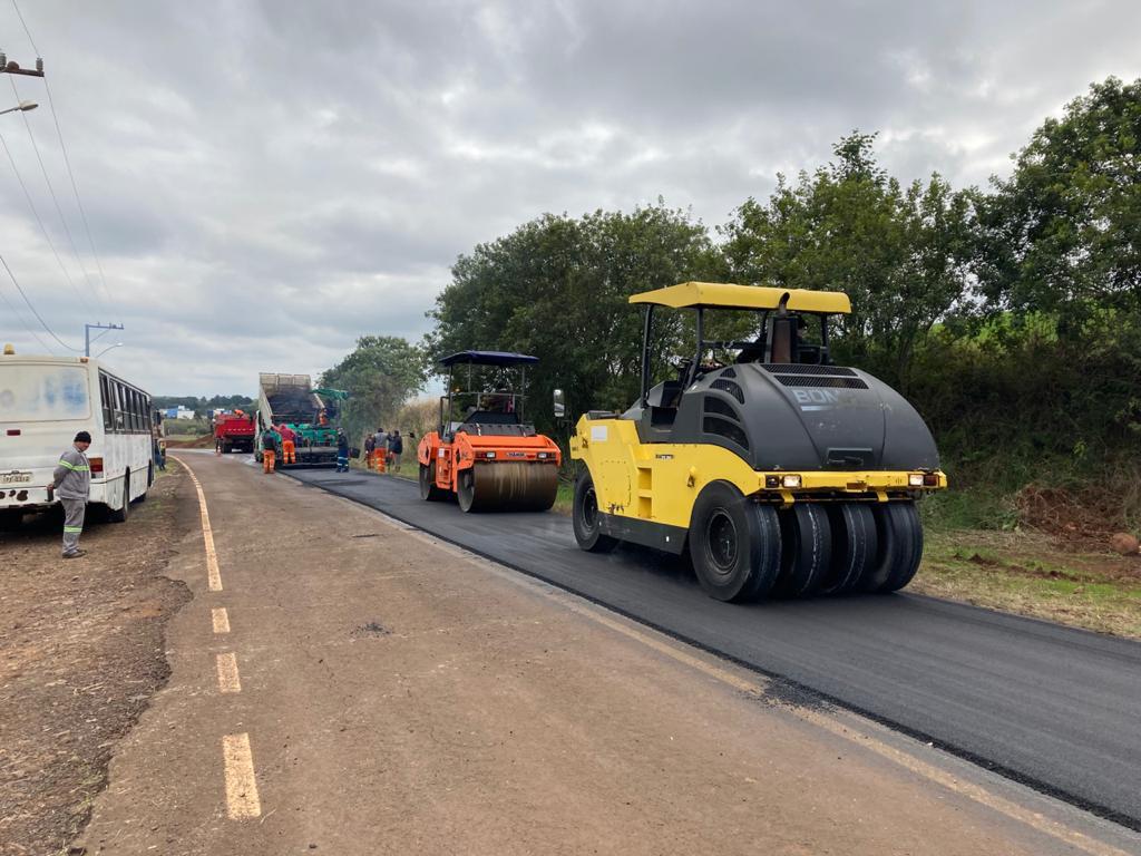 Imagem de trecho de acesso à UFSM-FW. À direita, aparecem máquinas realizando manutenção na massa asfáltica recém colocada.