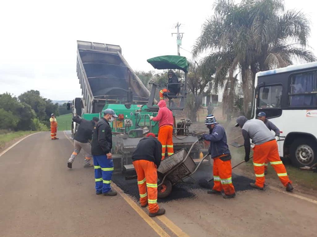 Imagem com trecho de acesso à UFSM-FW. Aparecem na imagem trabalhadores realizando manutenção do asfalto.