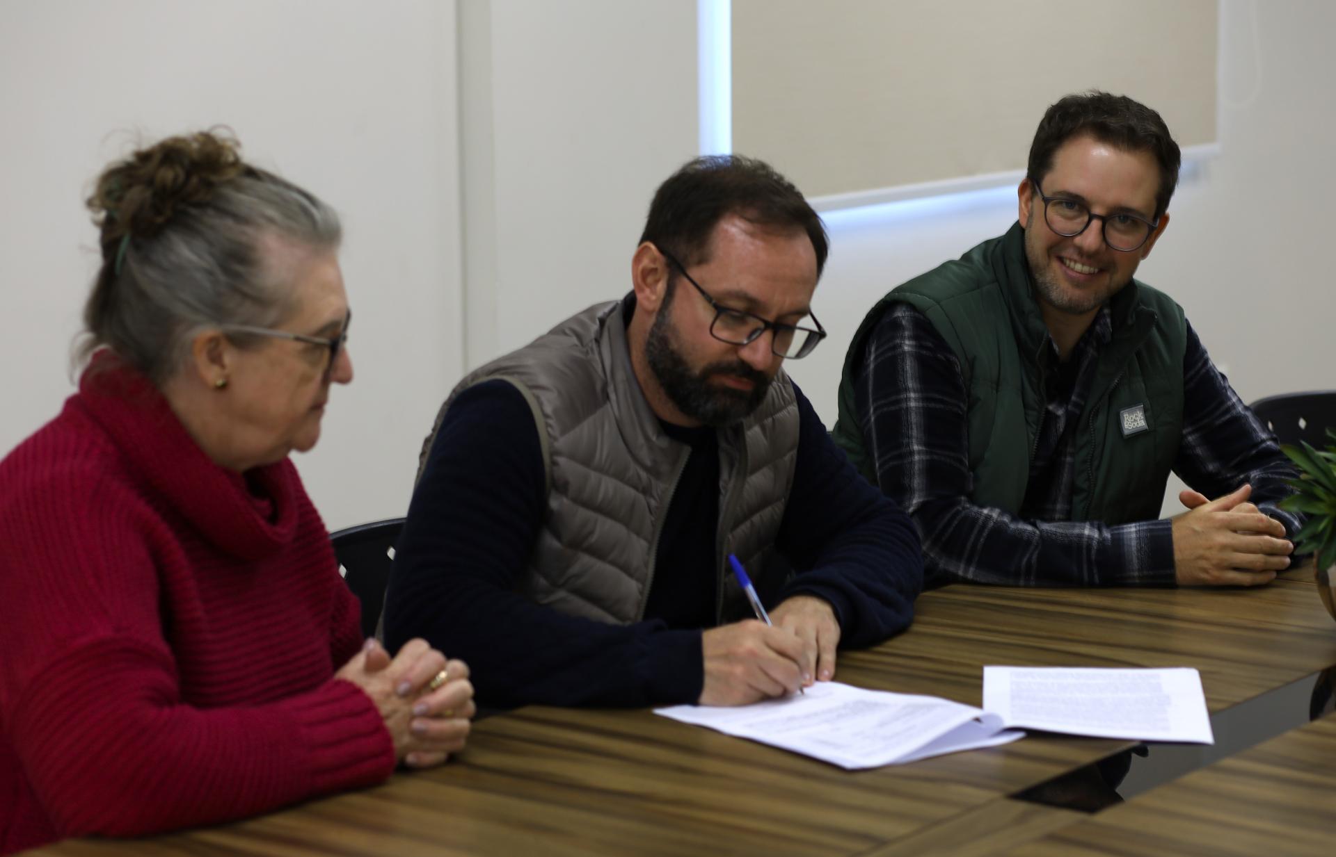 Imagem registra o momento em que contrato é firmado