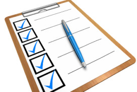 Descrição da imagem: prancheta com folha branca contendo uma coluna à esquerda com 5 quadrados, um abaixo do outro, com a marcação de um V dentro de cada um, sinalizando a checagem de uma lista. Ao lado de cada quadrado está uma linha. Em cima da folha está uma canela na cor azul.