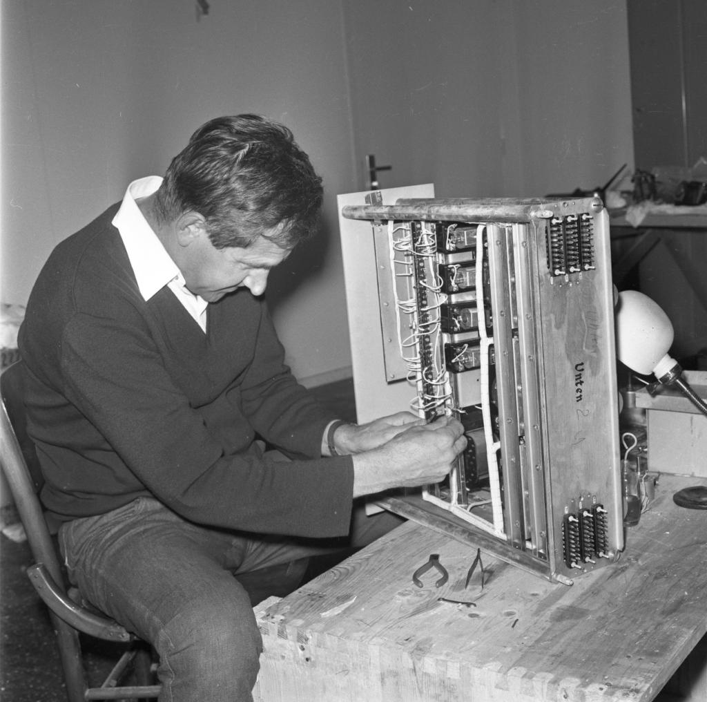 Foto preto e branco de homem operando equipamentos do Planetário