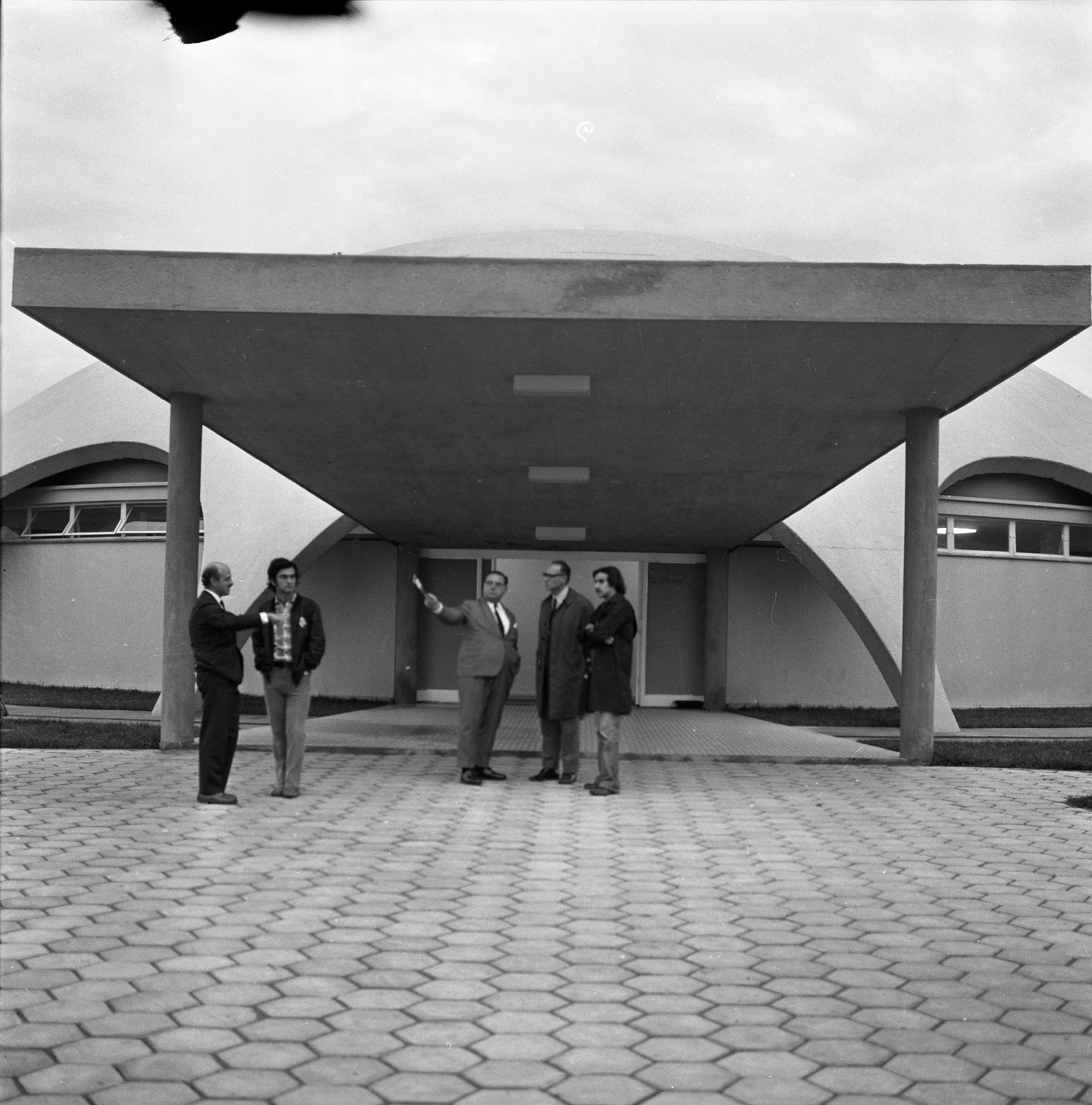 Foto preto e branca com pessoas paradas na entrada do Planetário