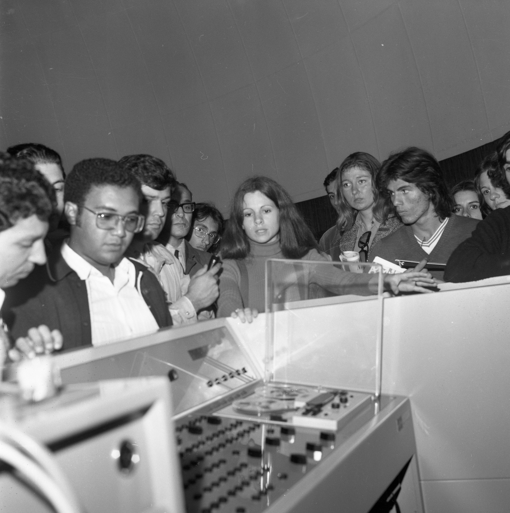 Foto preto e branca de crianças olhando equipamentos na Sala de Projeções do Planetário