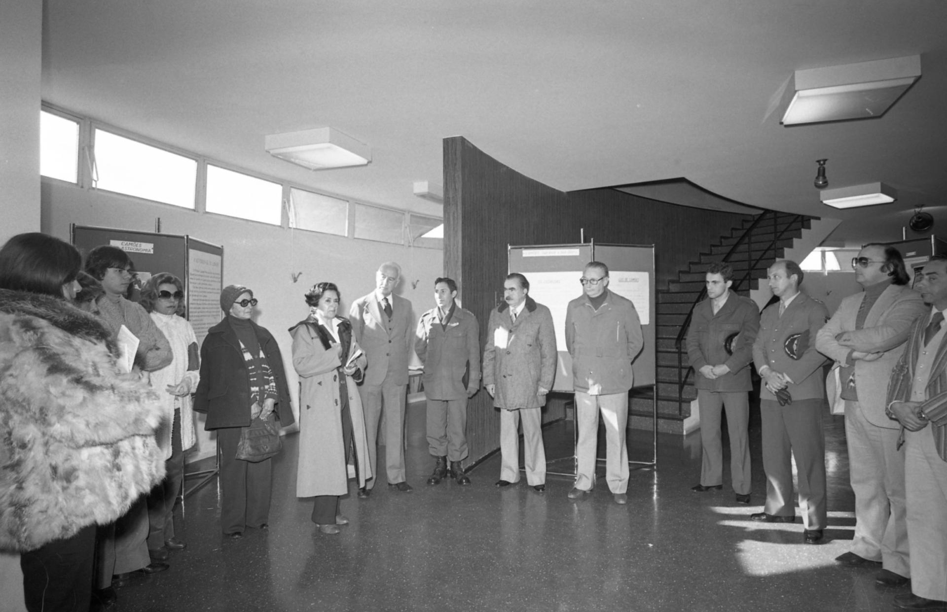 Foto preto e branca de diversas pessoas em pé no hall do Planetário