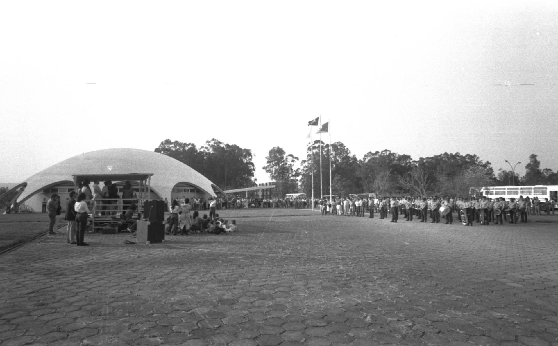Foto preto e branca de evento em torno do Planetário com diversas pessoas em pé