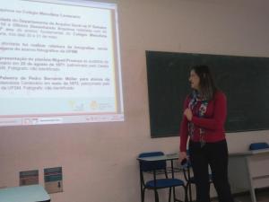 Fotografia horizontal colorida de uma mulher ao lado de uma projeção na parede