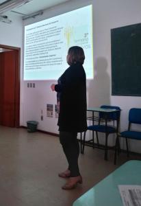 Fotografia vertical colorida de uma mulher em frente a uma projeção na parede