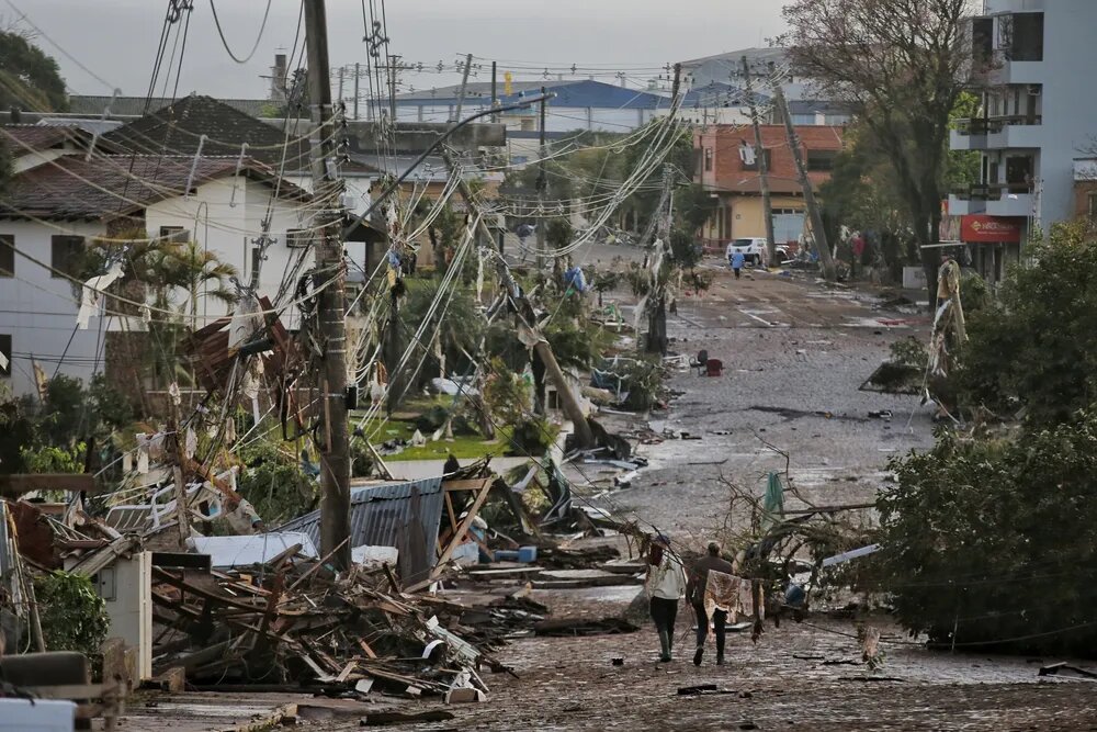 A foto mostra uma rua da cidade de Roca Sales com postes caídos e casas destruídas.