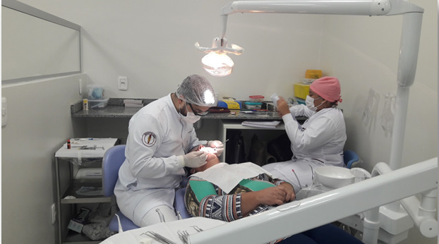 acadêmico de odontologia realizando tratamento dentário em uma senhora