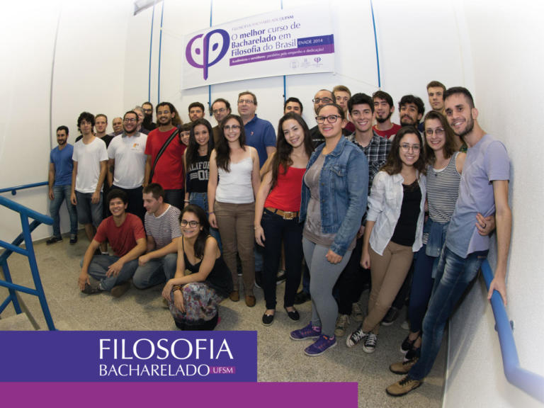 alunos de pé e ao fundo um banner do curso de filosofia