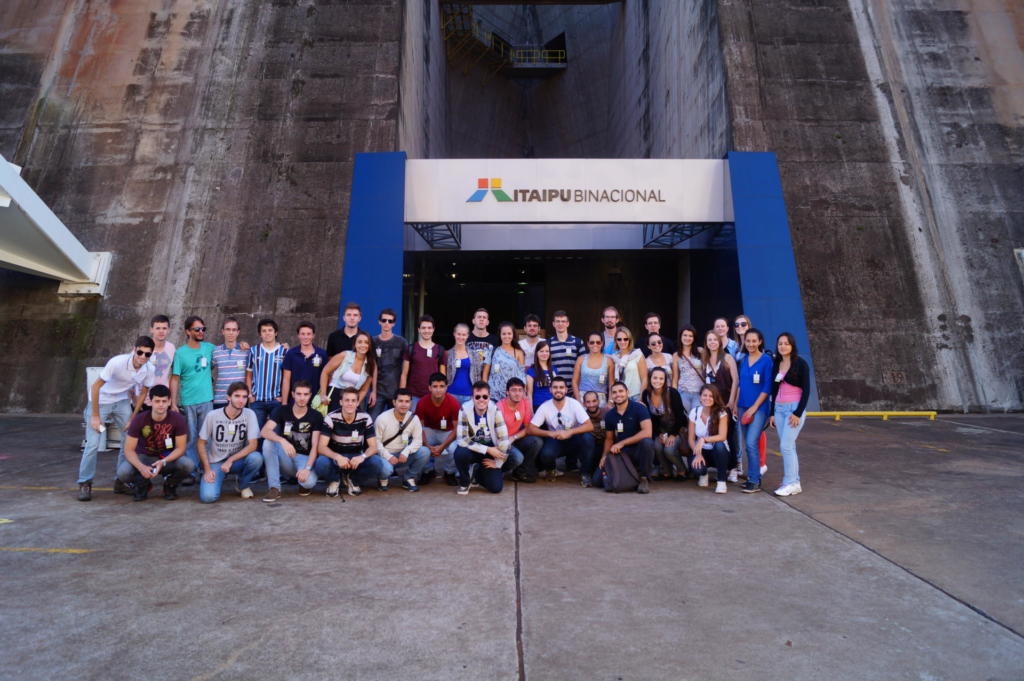 Foto de alunos posicionados lado a lado em frente a entrada do Itaipu Binacional.