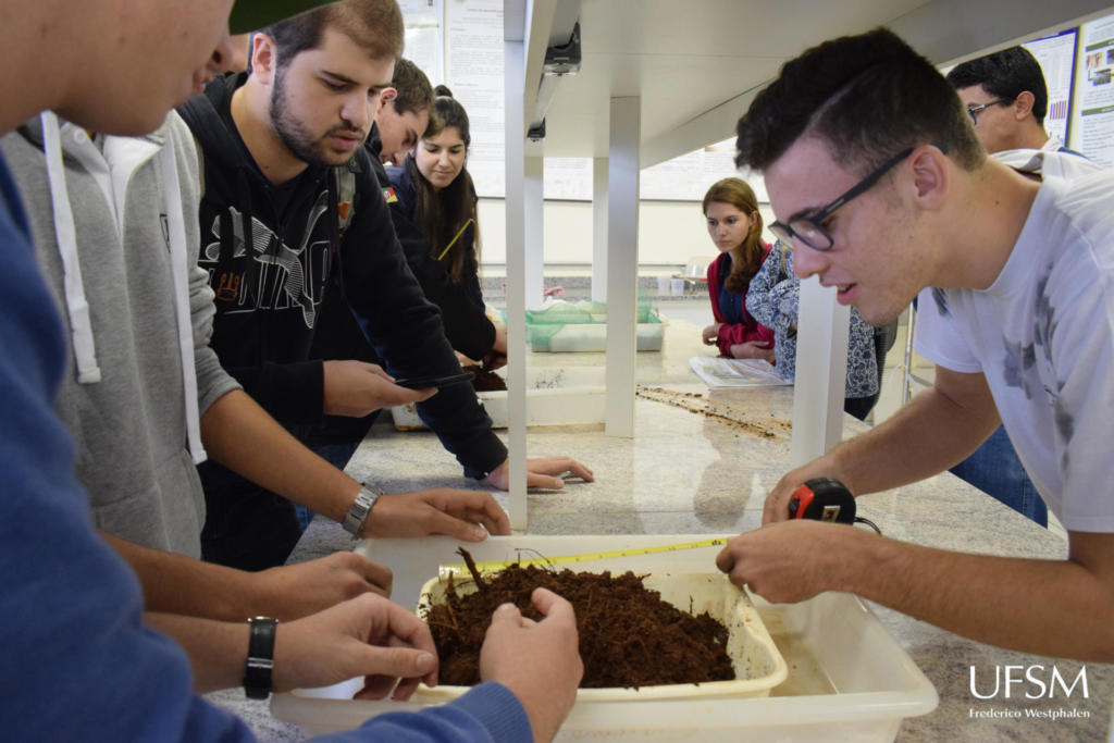 alunos no laboratório examinando a terra