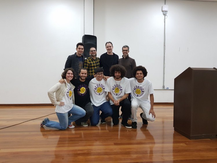 Foto de um grupo de pessoas, quatro homens de pé e a frente deles cinco pessoas de joelhos todos olhando para a câmera.