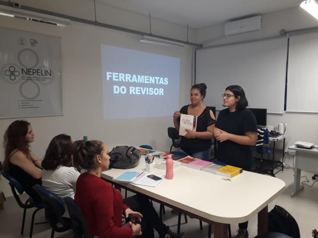 Duas meninas na frente da classe fazendo uma apresentação