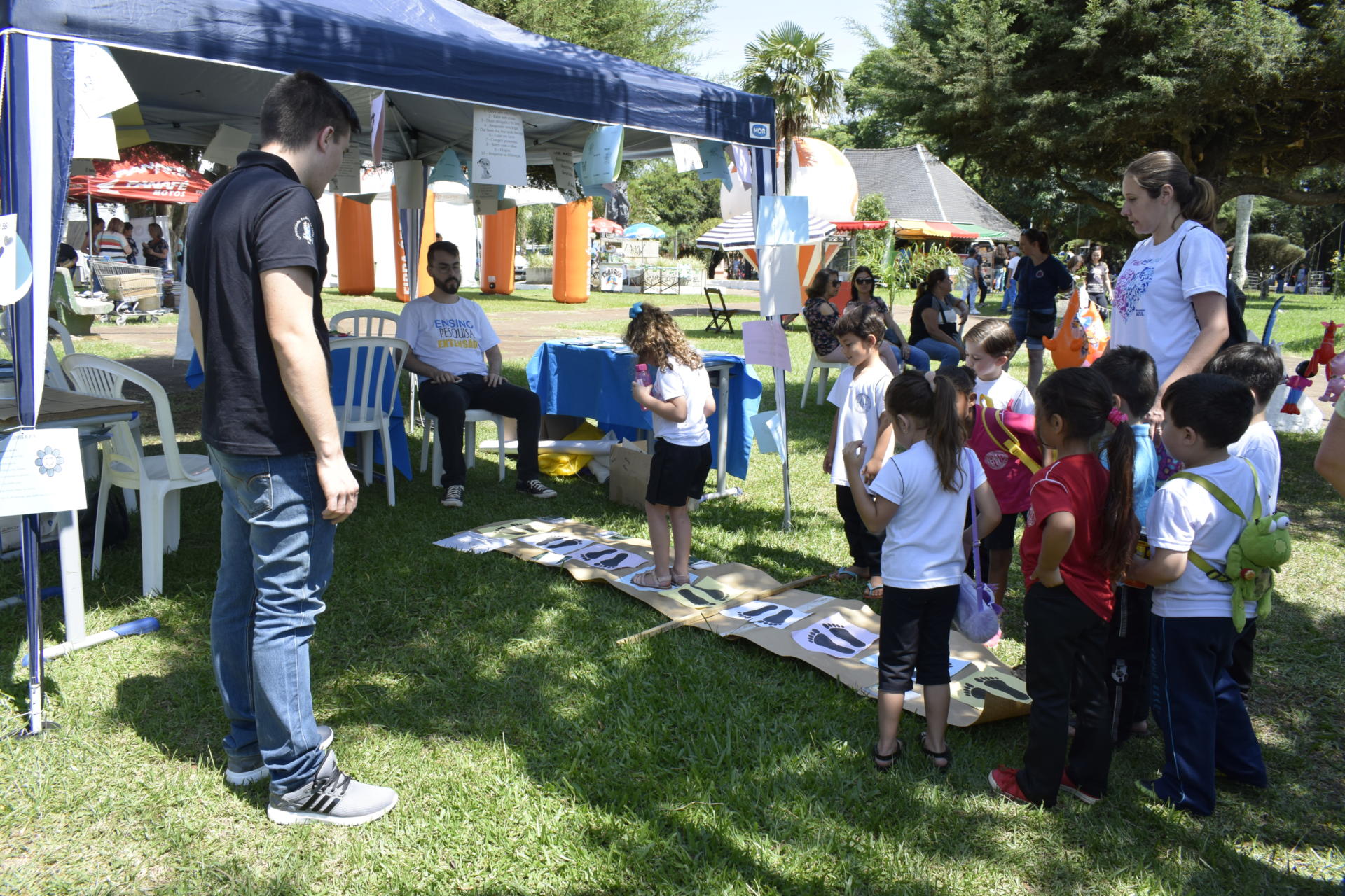 Foto de stand na Feira do Livro com diversas crianças brincando na frente