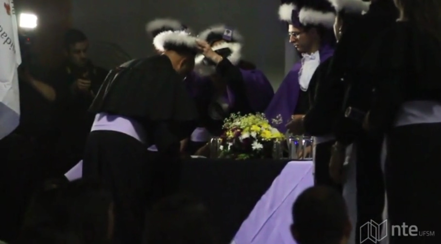 Aluno comprimentando a banca na formatura