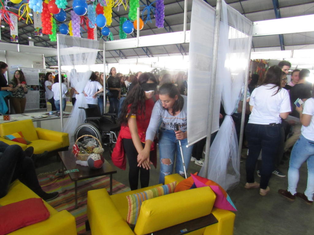 Mulher ajudando uma menina a se localizar na estande do curso no descubra