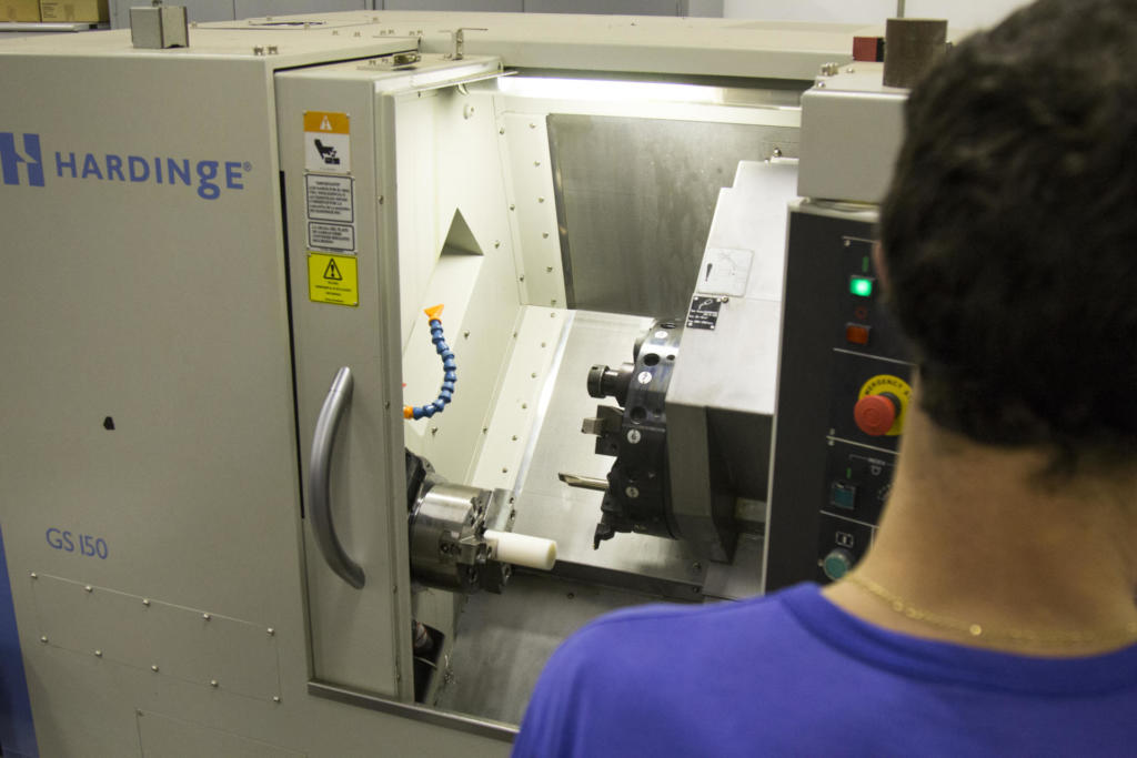 Fotografia de um aluno de costas para nós, visualizando uma máquina.