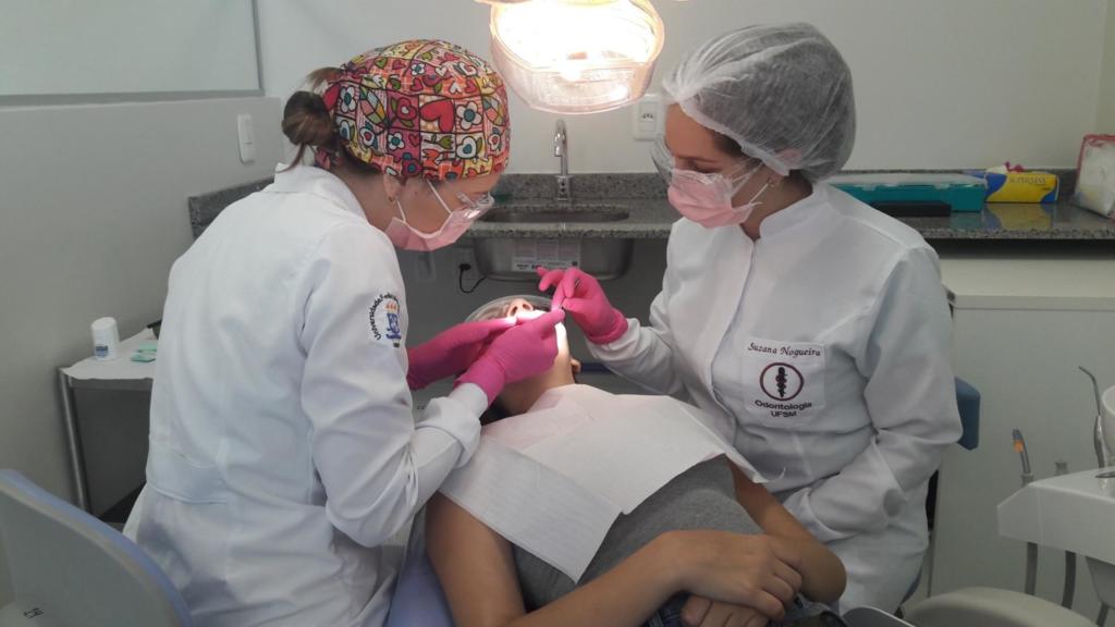 Acadêmica de odontologia realizando tratamento dentário em uma criança