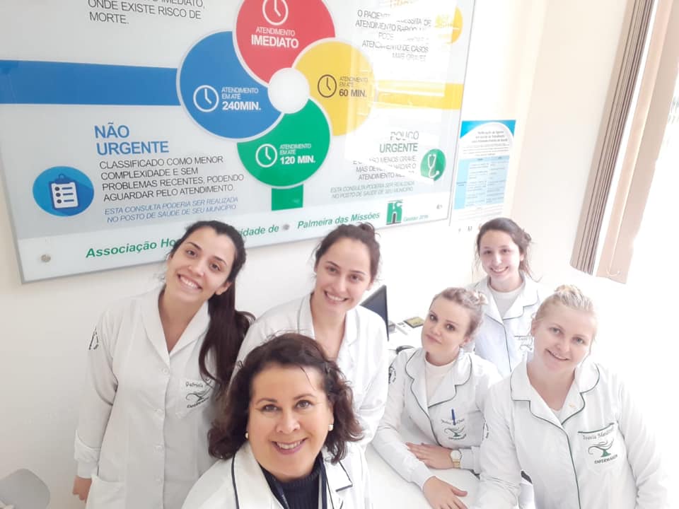 Alunas brancas do curso de enfermagem Palmeira das Missões, realizando estágio na emergência de um hospital. Todas estão sorrindo para uma selfie