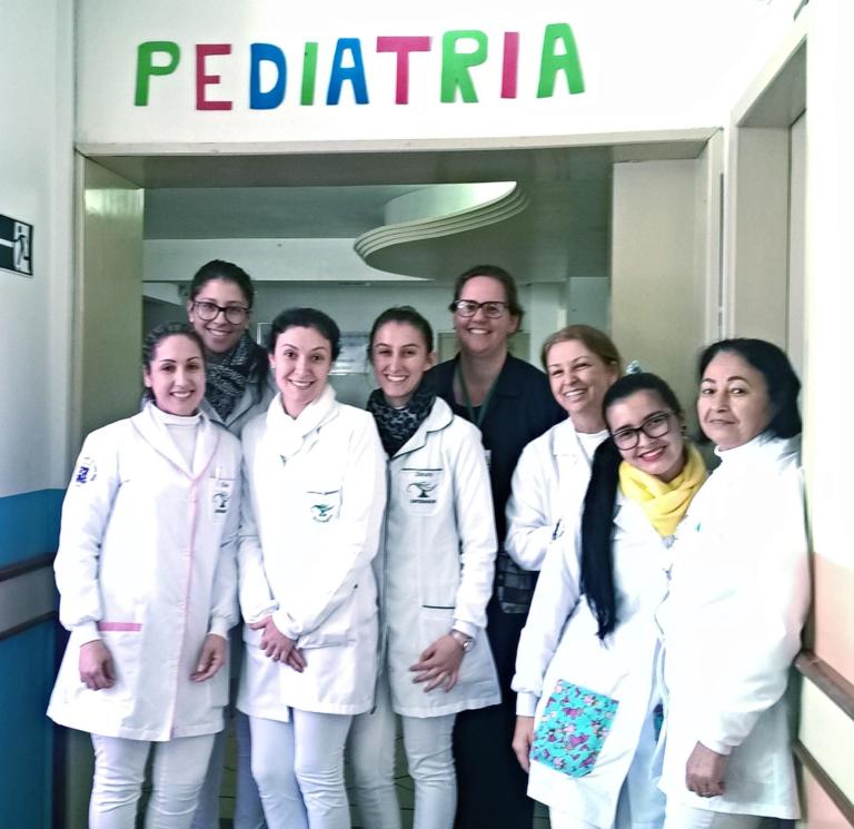 Alunas do Curso de Enfermagem Palmeira das Missões realizando estágio na pediatria de um hospital. Todas estão sorrindo para uma foto