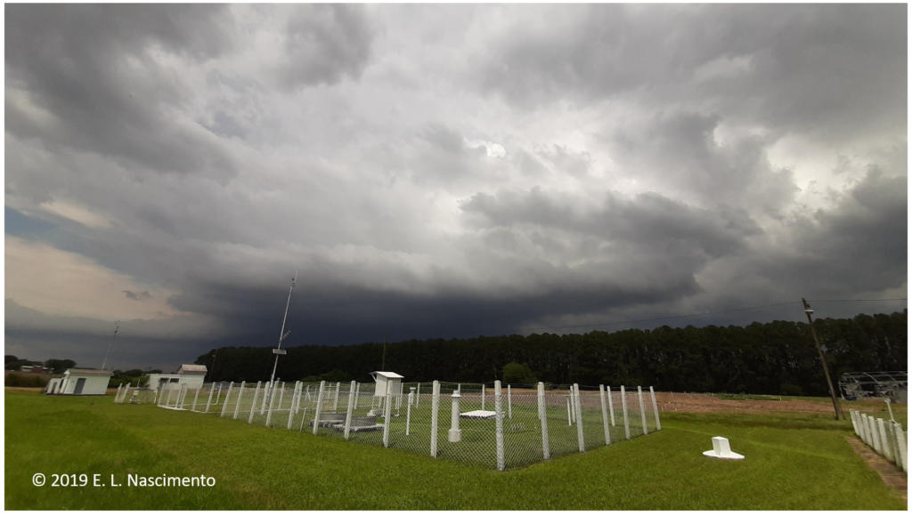 Foto de um local aberto, um campo, onde aparece o céu bem nublado.