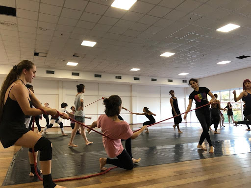 Com cordas, alunos do curso de dança licenciatura, se exercitam em aula.