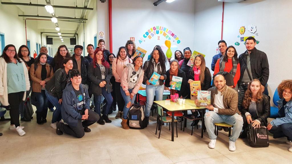 Diversas pessoas em pé segurando livros