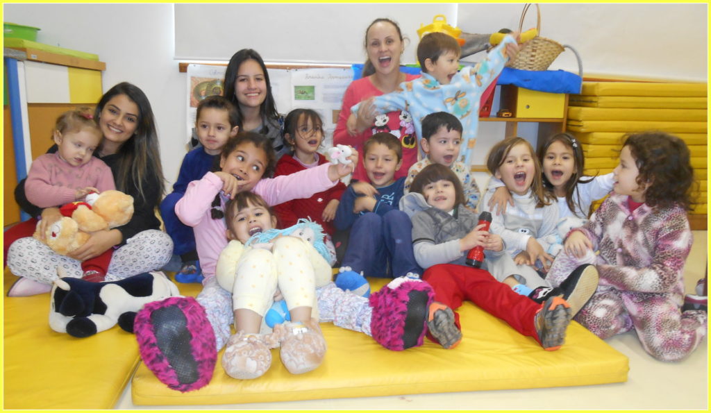 Turma de crianças sentadas no chão com professoras