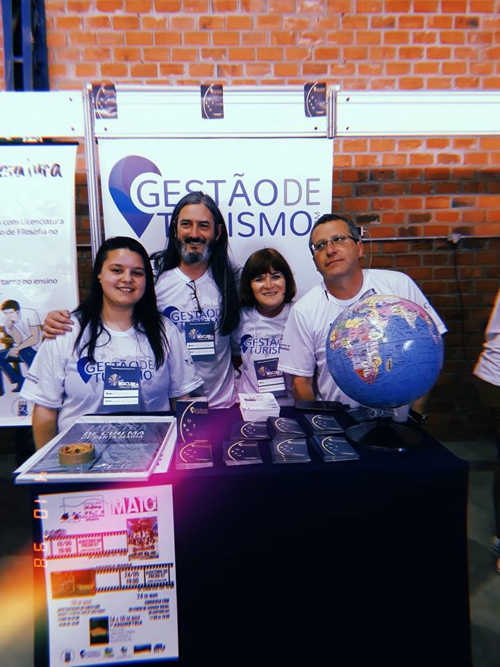 Quatro pessoas em pé em stand do Descubra