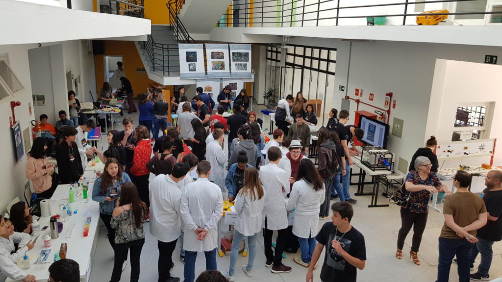 Hall de prédio cheio de pessoas e banners de apresentação