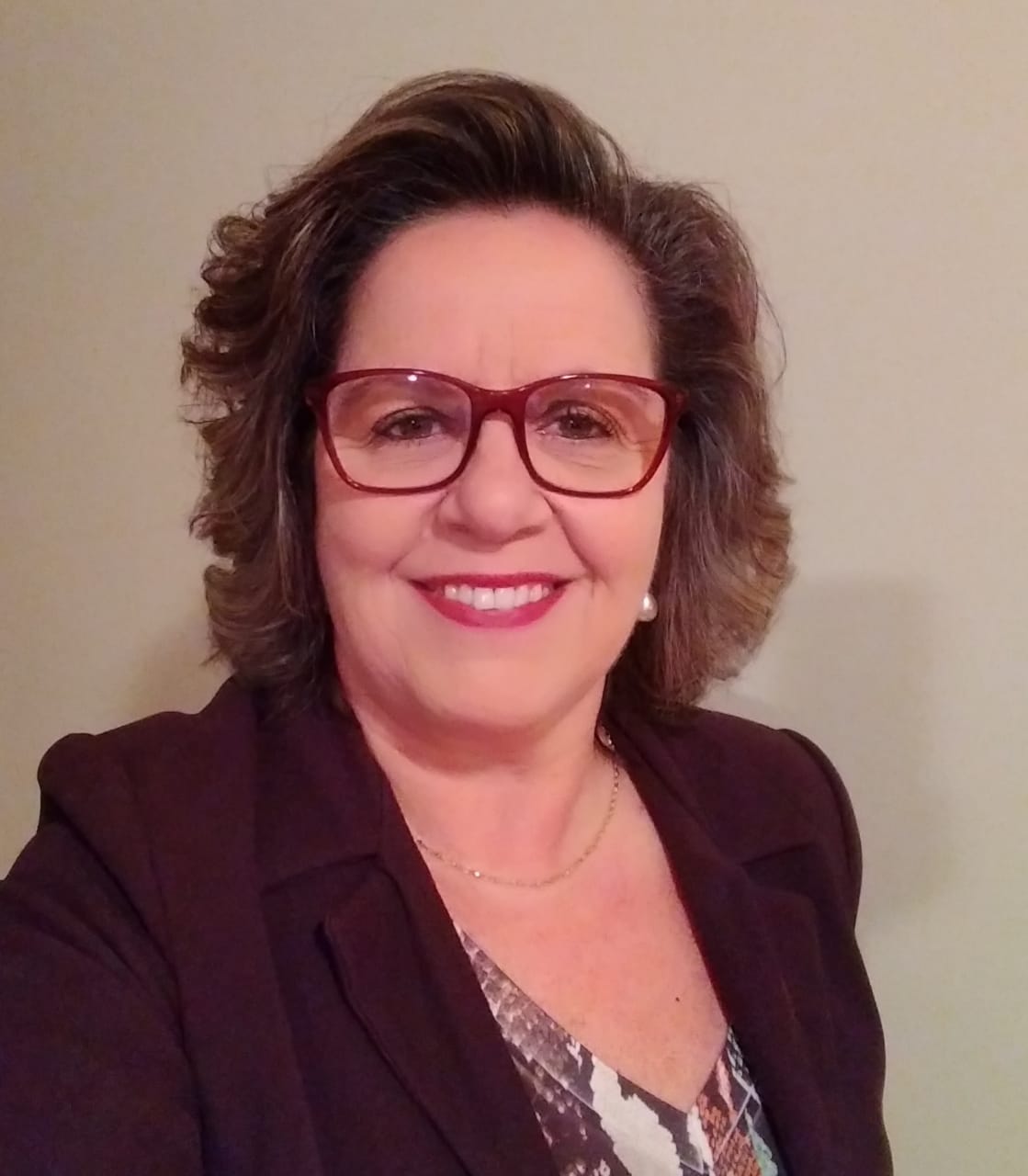 Foto perfil de mulher de terno usando óculos de grau