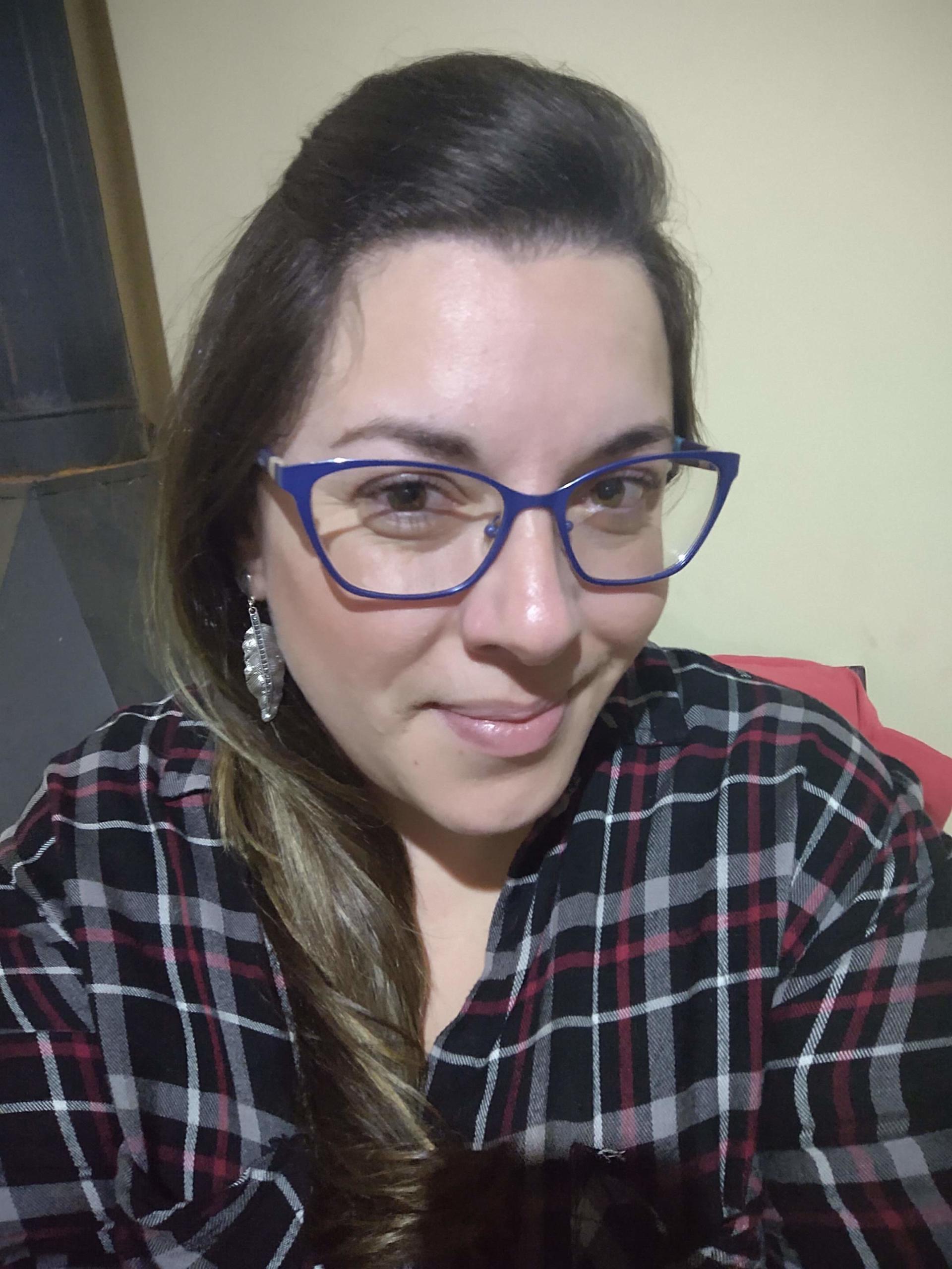 Foto perfil mulher loira com camisa xadrez e óculos de grau
