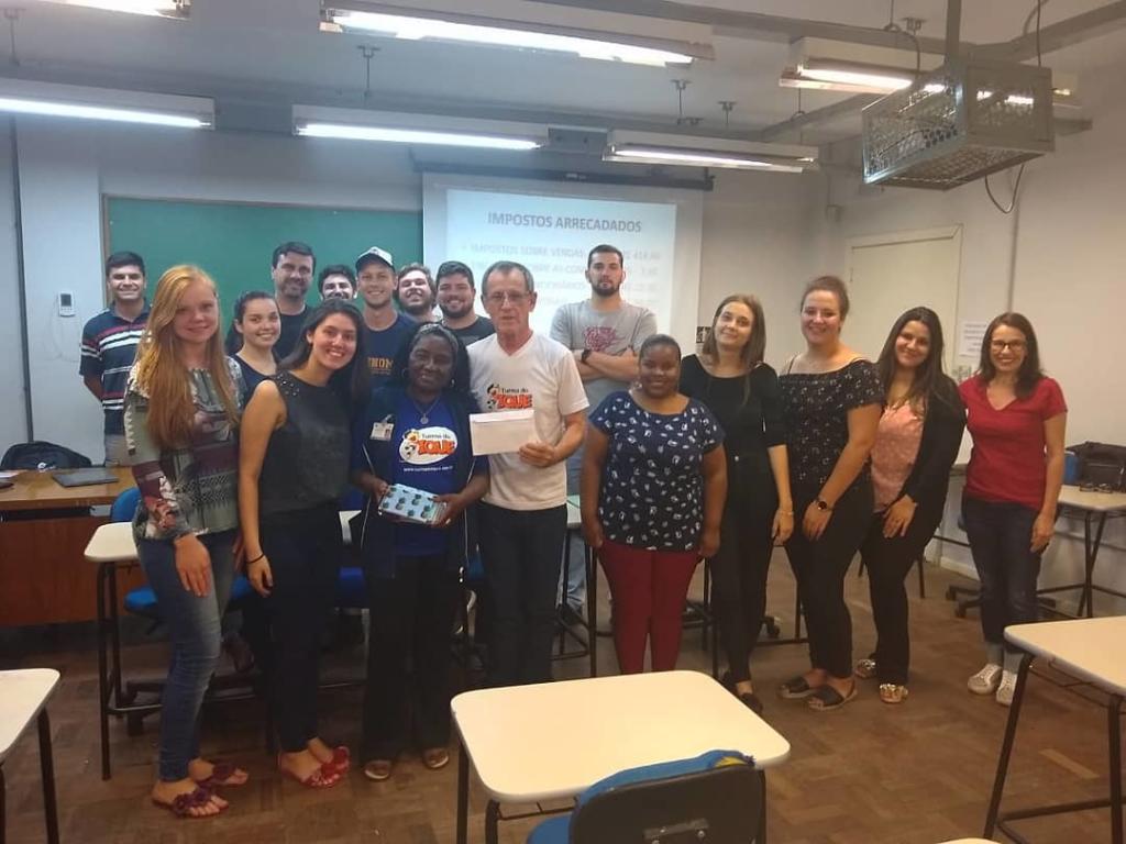 Foto de diversas pessoas em pé em uma sala de aula