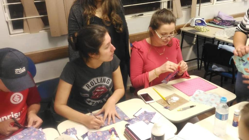 Foto de duas mulheres trabalhando na mesa com tecidos